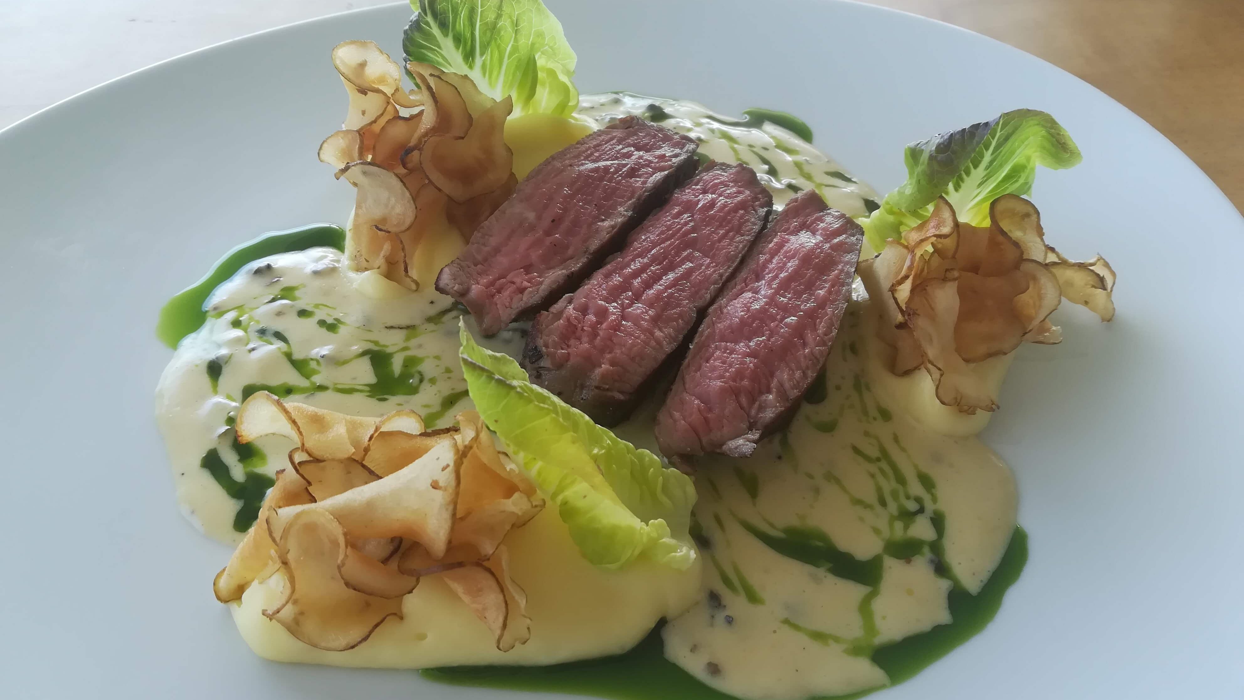 Steak mit Kartoffelchips, Salat und Soße verfeinert