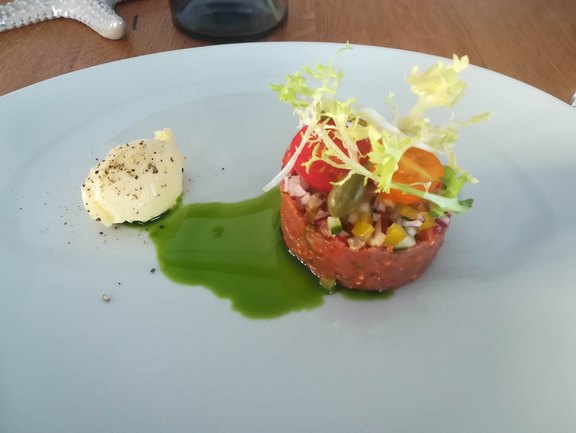 Beef Tartar auf einem weißen Teller serviert