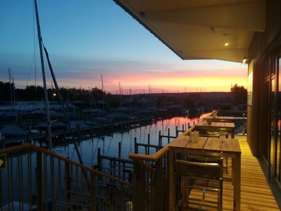 Blick von der Terrasse auf den See bei Sonnenuntergang